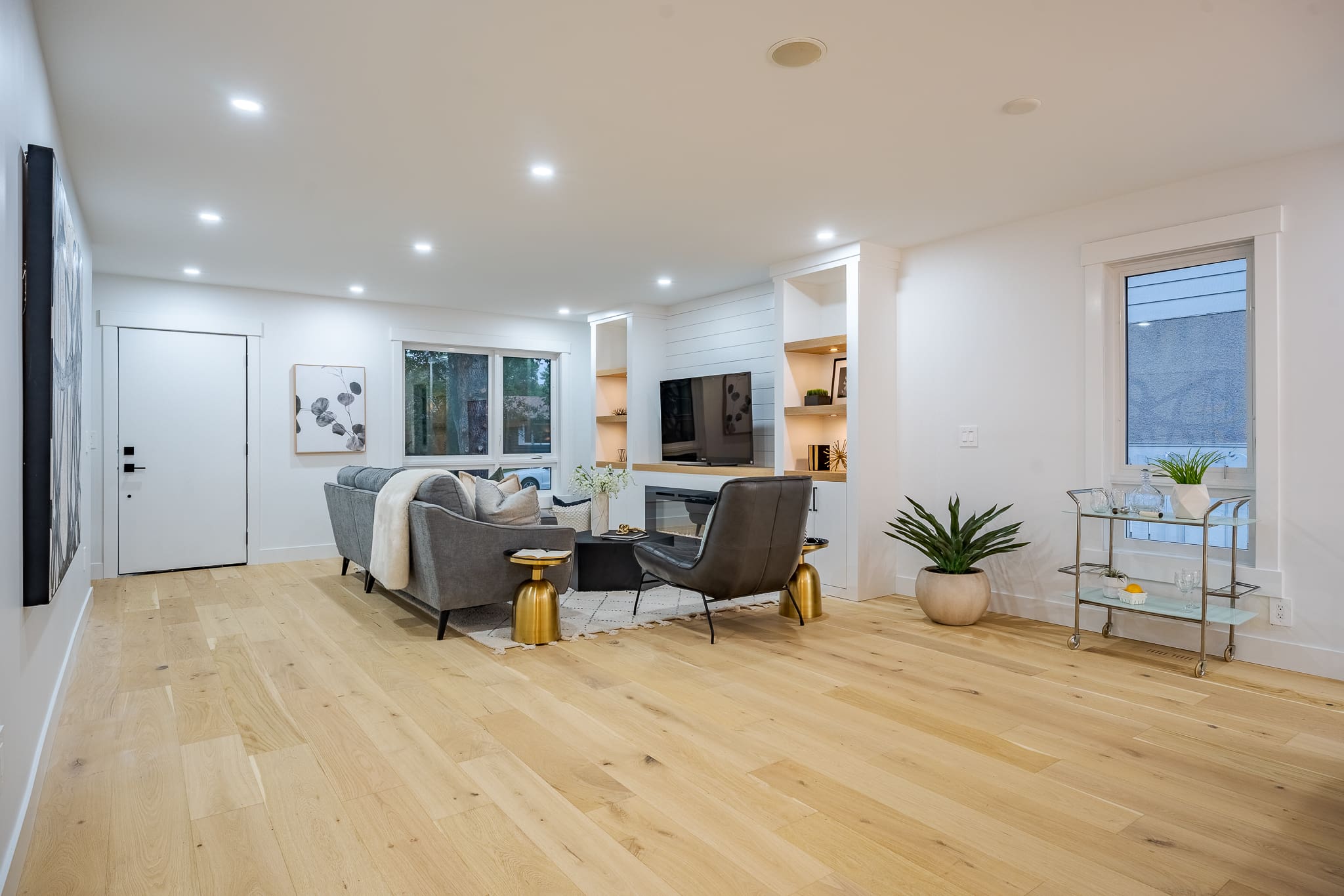 A living room with hard wood floors and white walls.