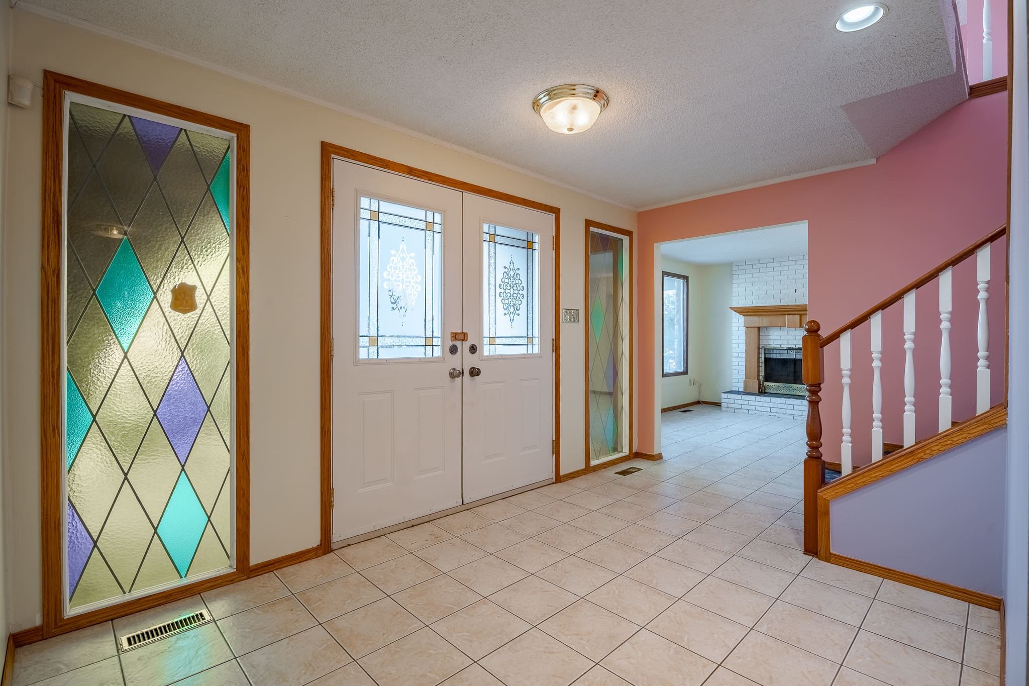 A large room with two doors and a fireplace.