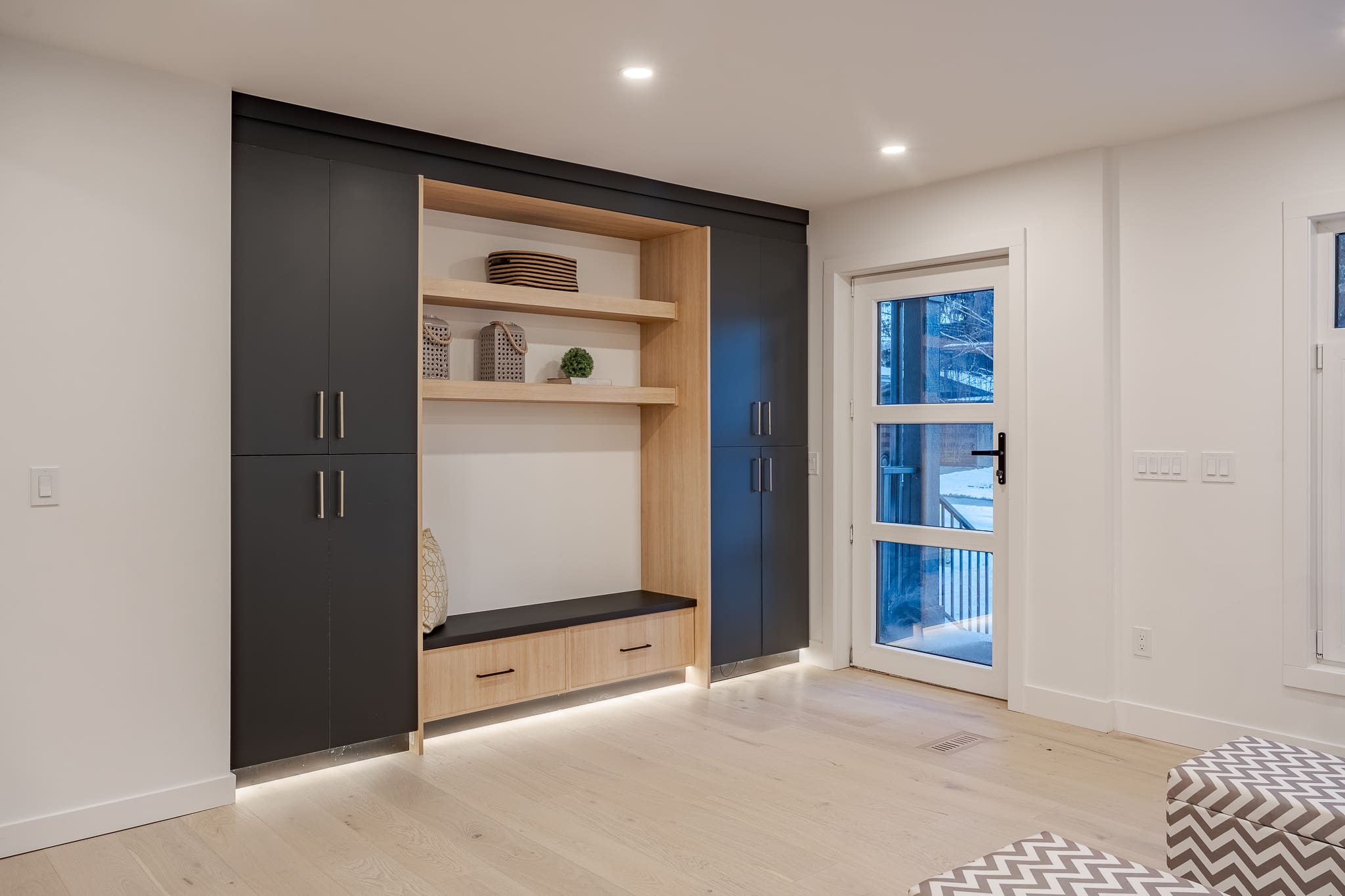 A room with black and white walls, a bench in the center of it.