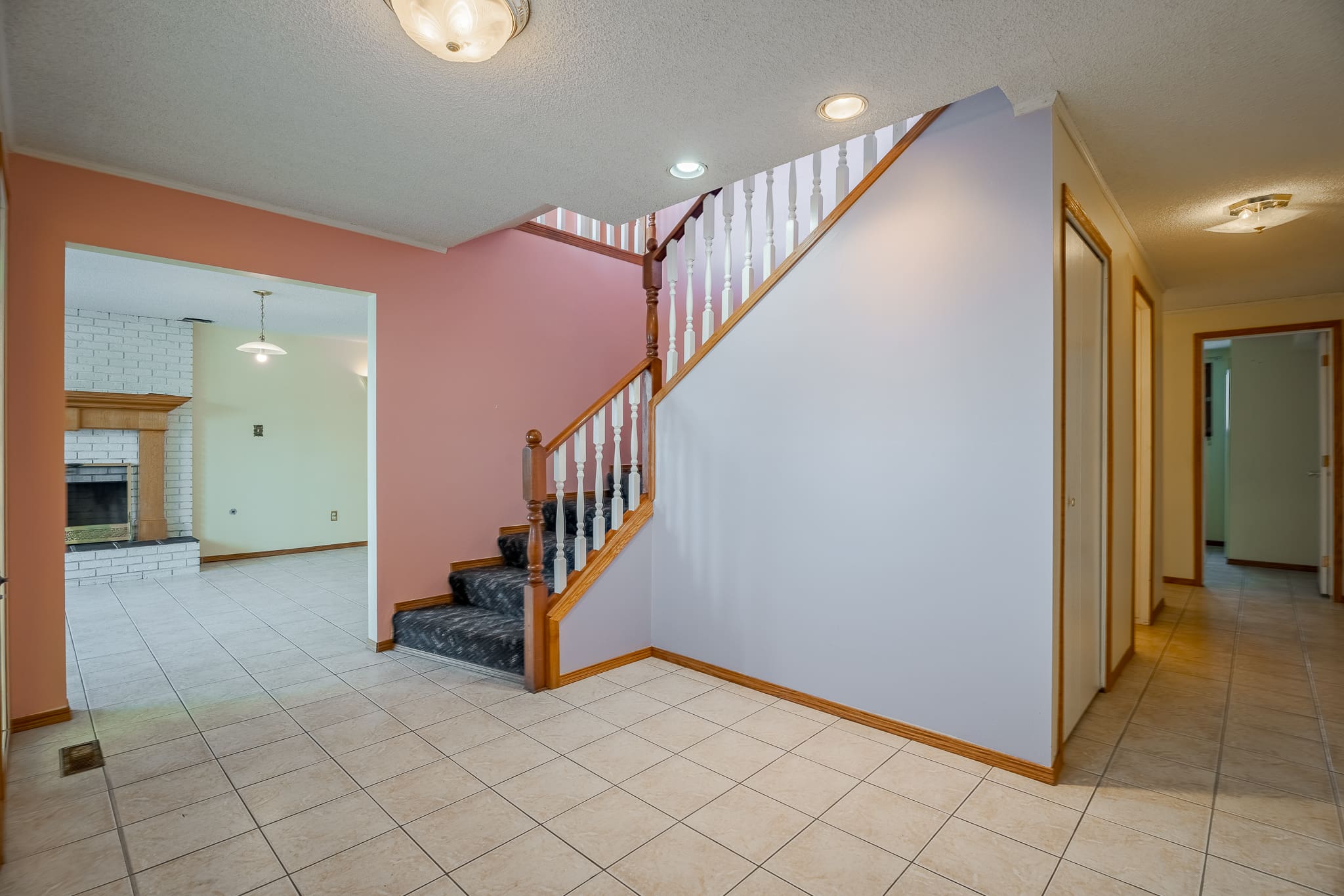 A large room with stairs and tiled floors.