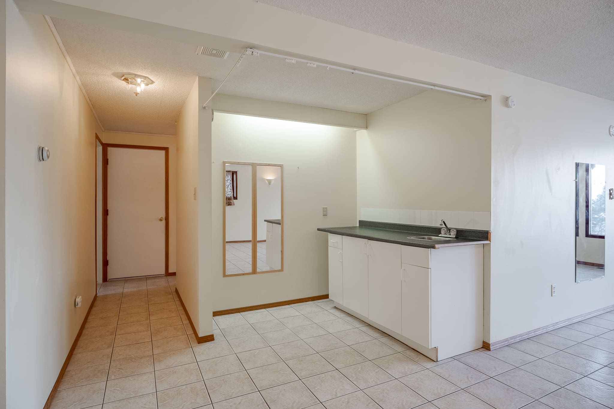 A kitchen with white tile floors and walls.