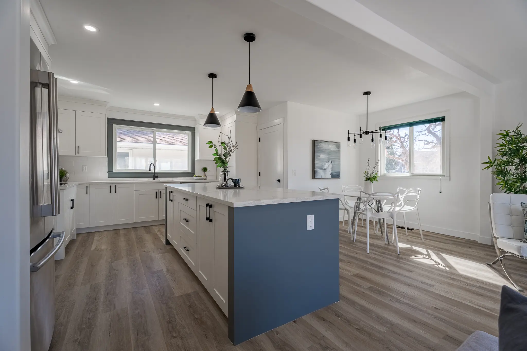 A kitchen with a large island and wooden floors