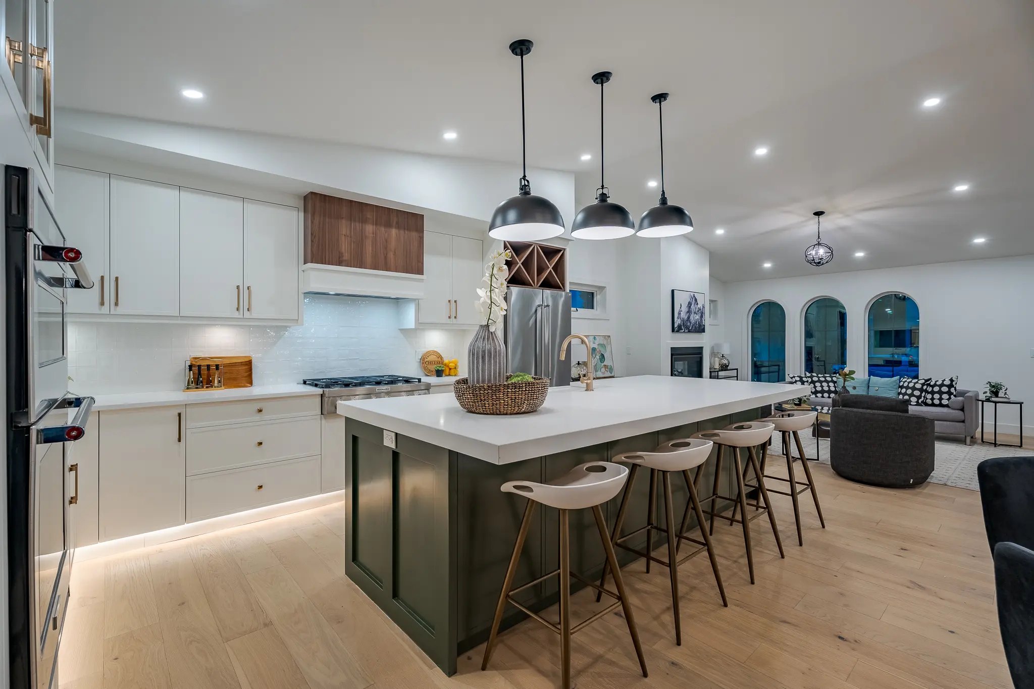 A kitchen with white cabinets and wooden floors.