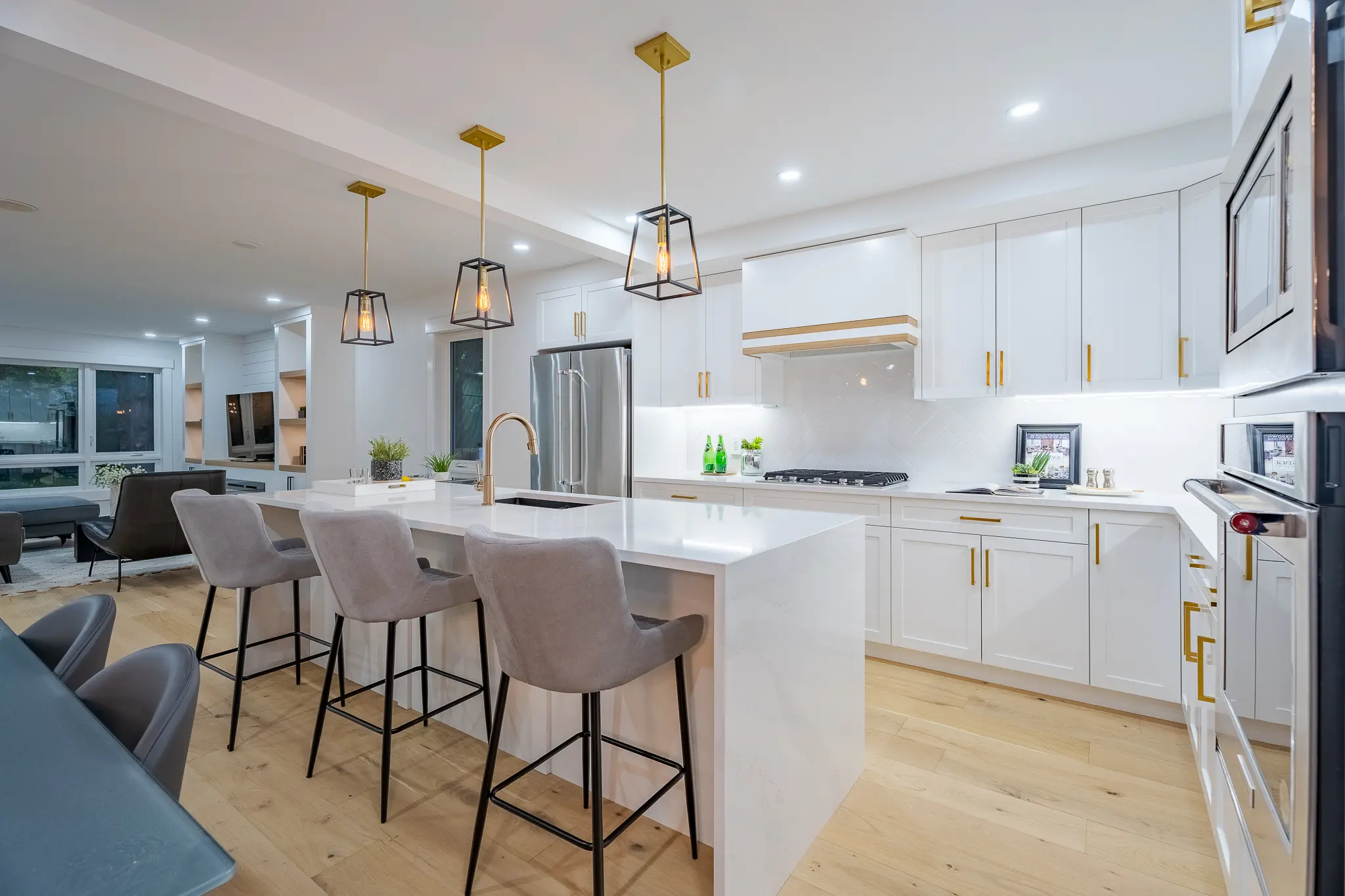 A kitchen with white cabinets and wooden floors.