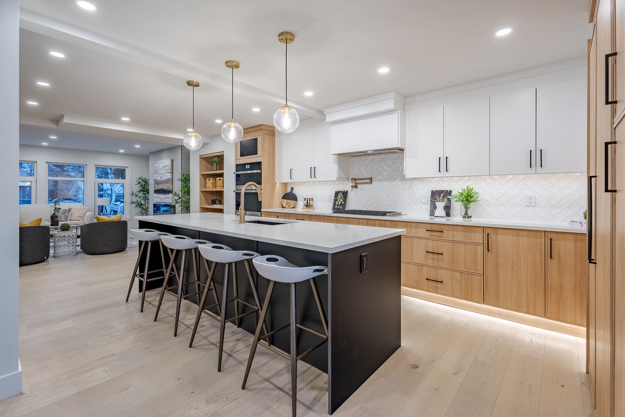 A kitchen with white cabinets and black island.