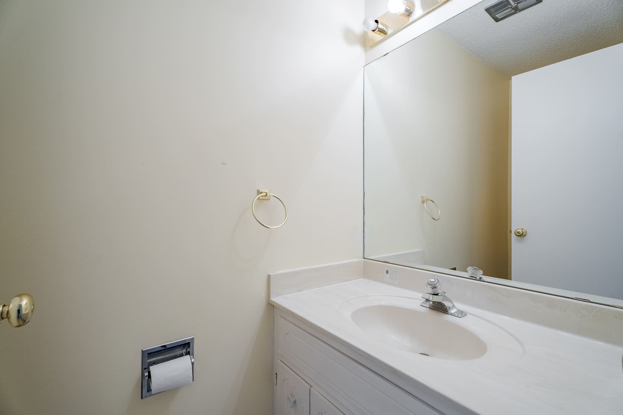 A bathroom with white walls and a sink.