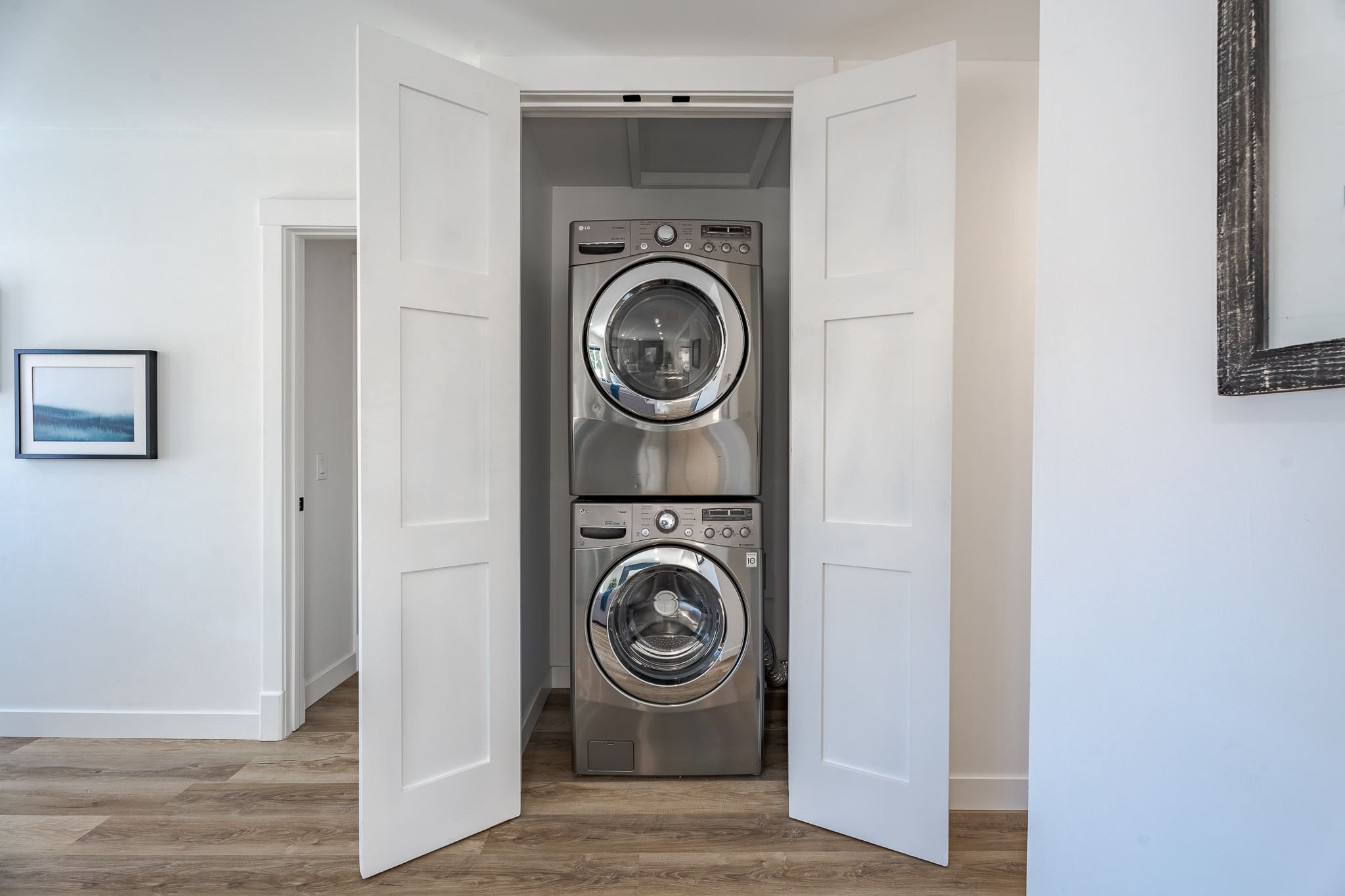 A room with two silver washing machines in it.