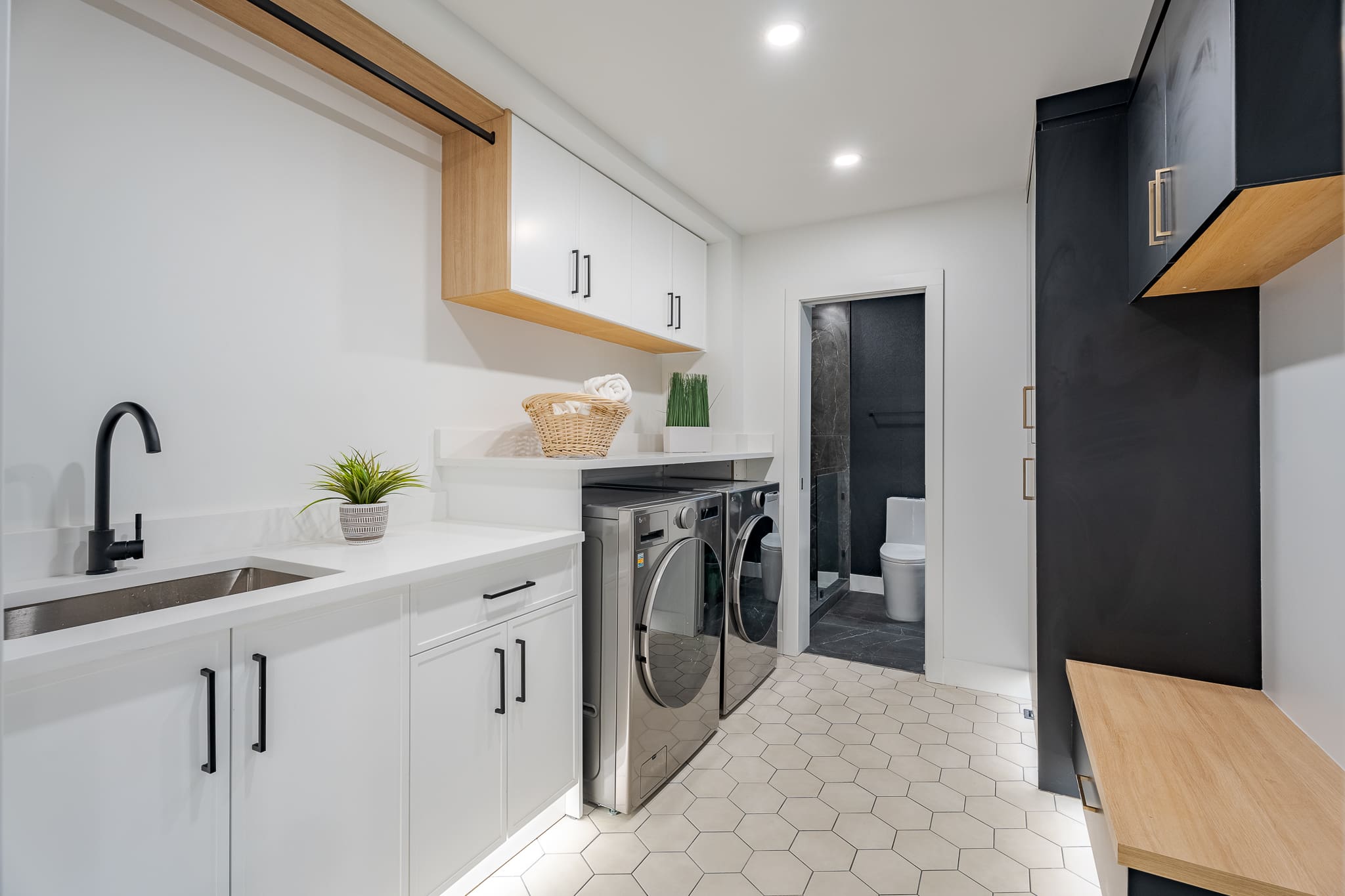 A white and black laundry room with a sink