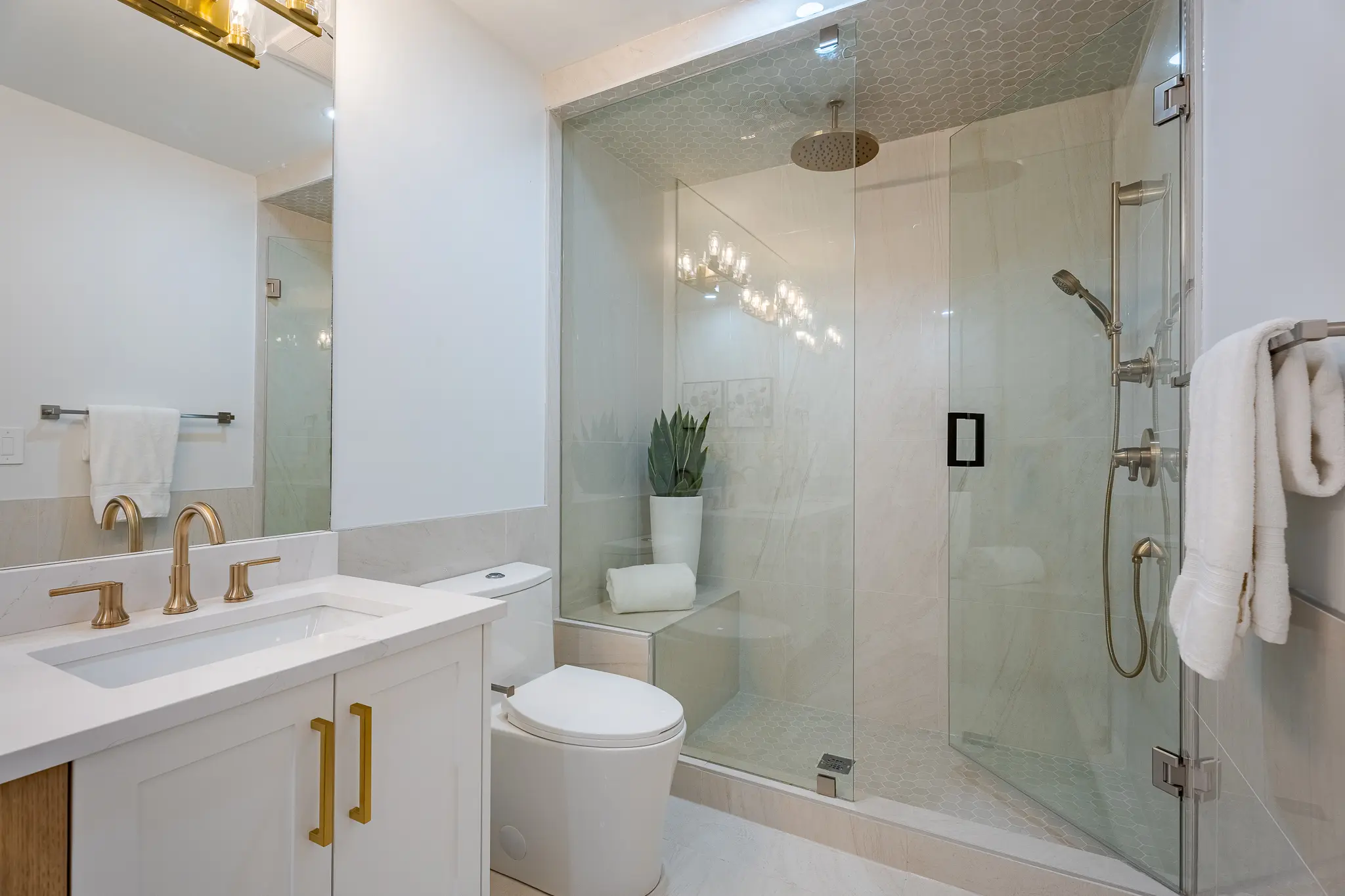 A bathroom with a toilet, sink and shower.