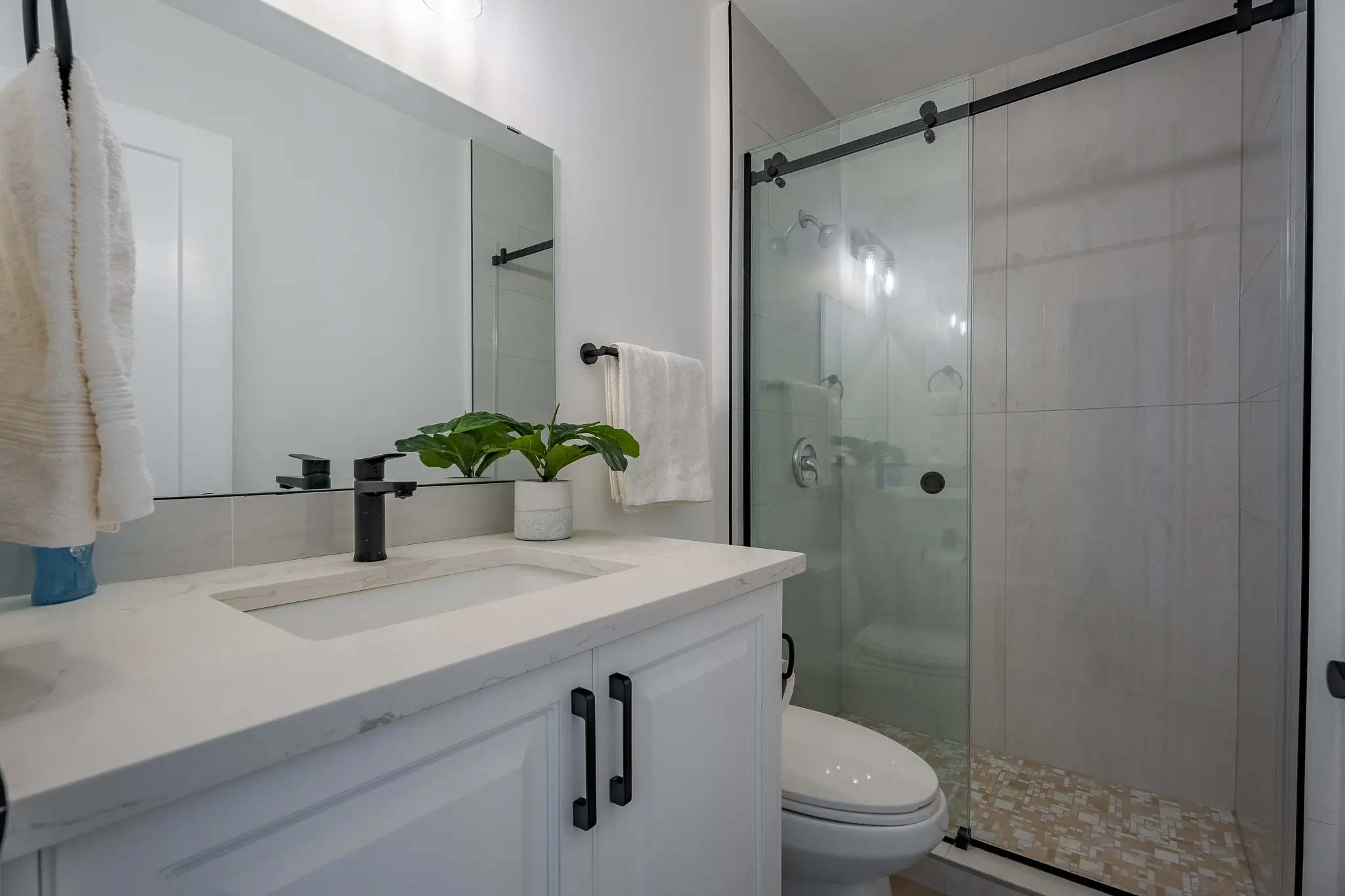 A bathroom with a toilet, sink and shower.