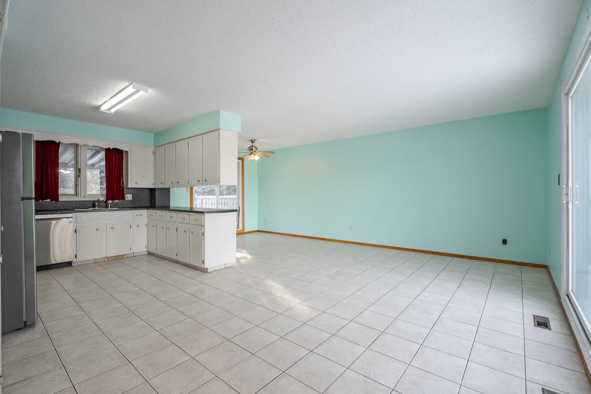 A kitchen with tile floors and white cabinets.