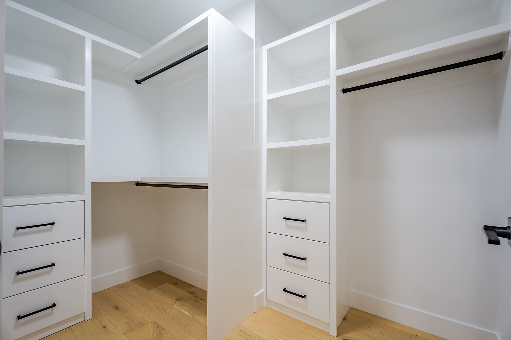 A white closet with shelves and drawers in it