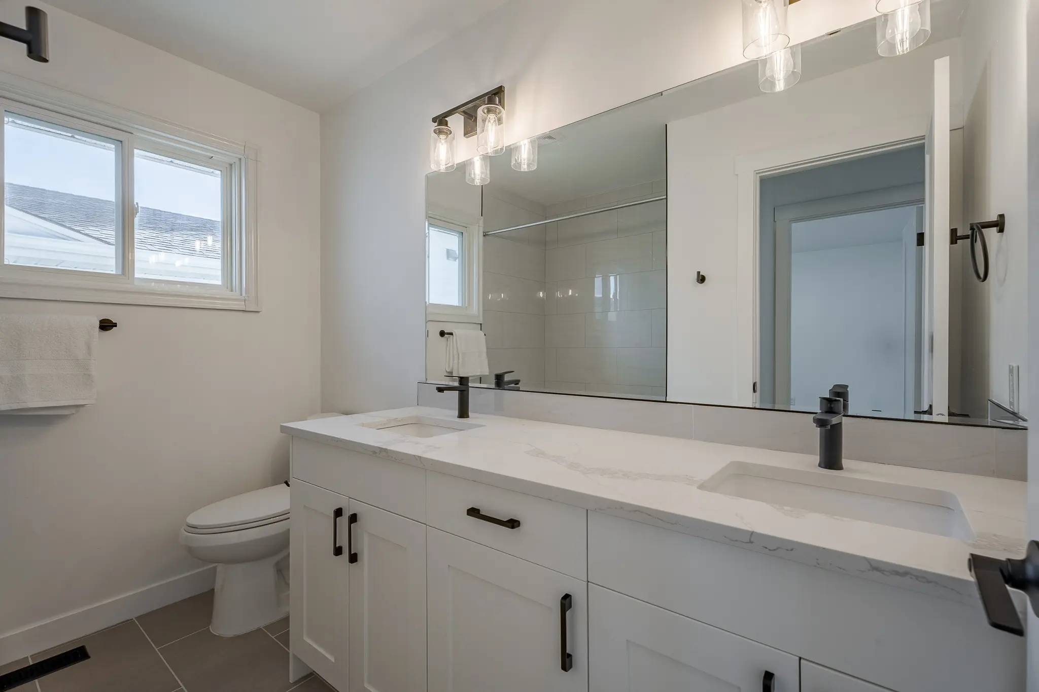 A bathroom with two sinks and a large mirror.