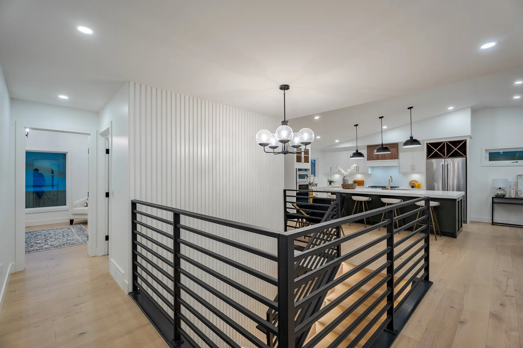 A view of the interior of a home with a black railing.