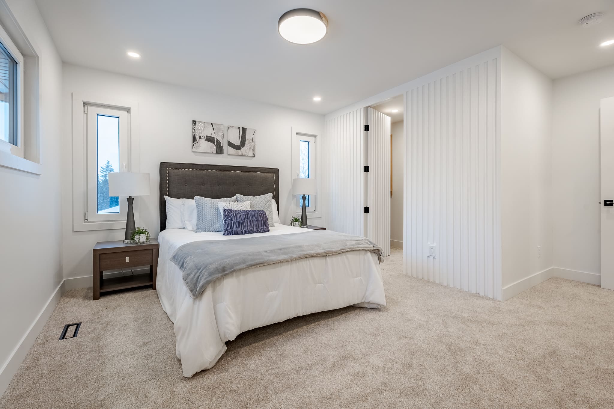 A bedroom with a bed, nightstand and window.