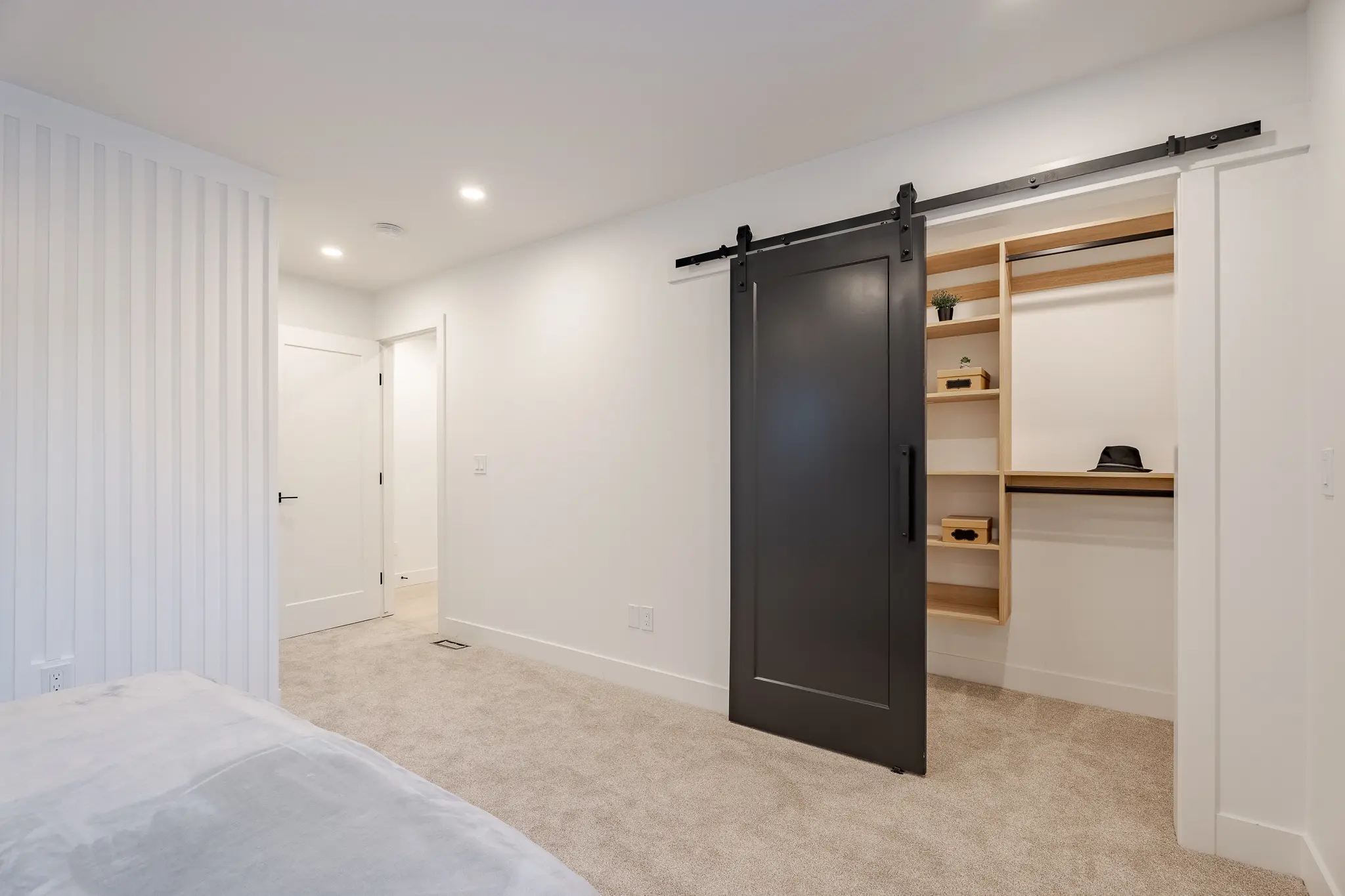 A bedroom with a black door and white walls