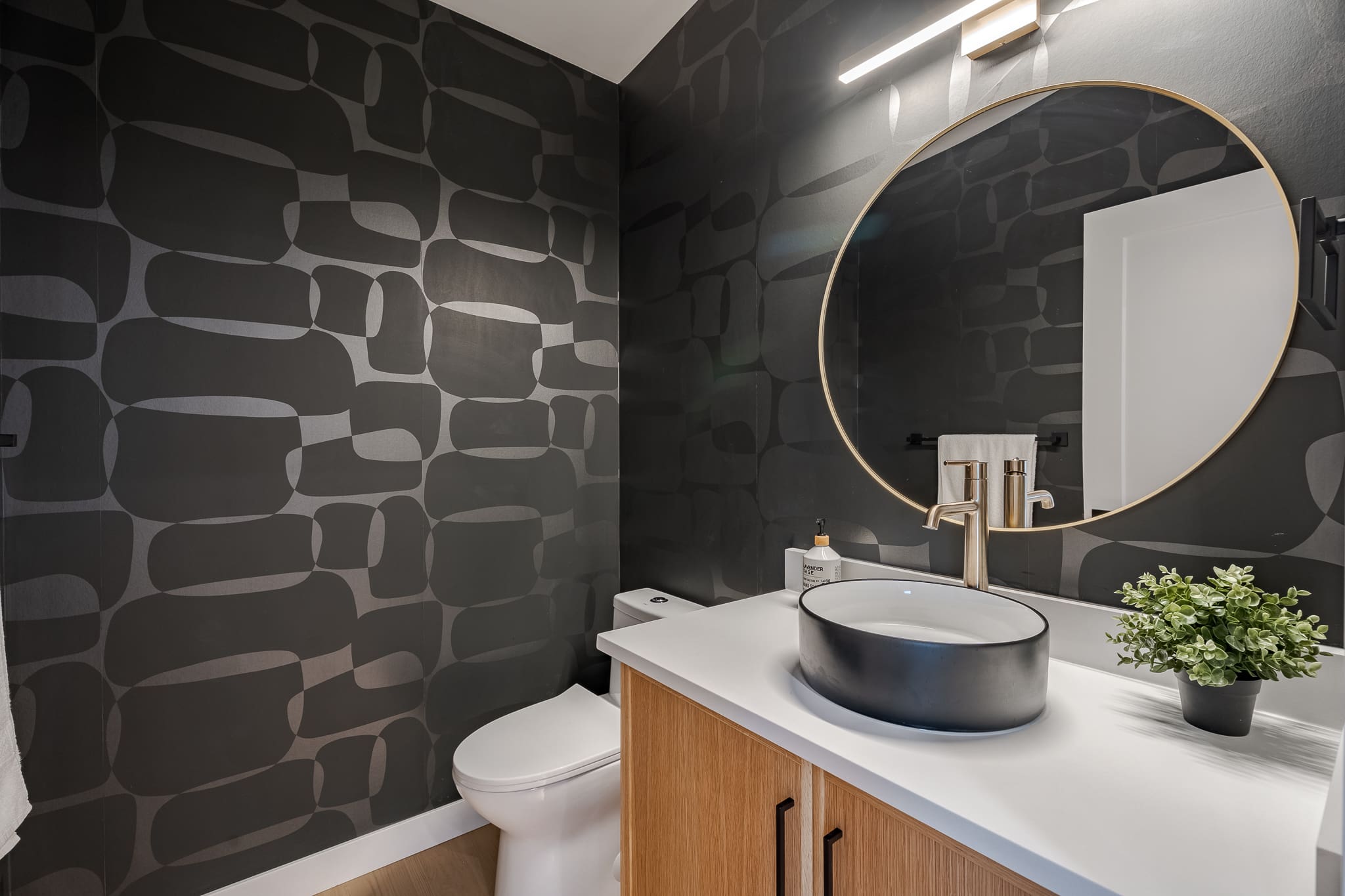 A bathroom with black walls and white fixtures.