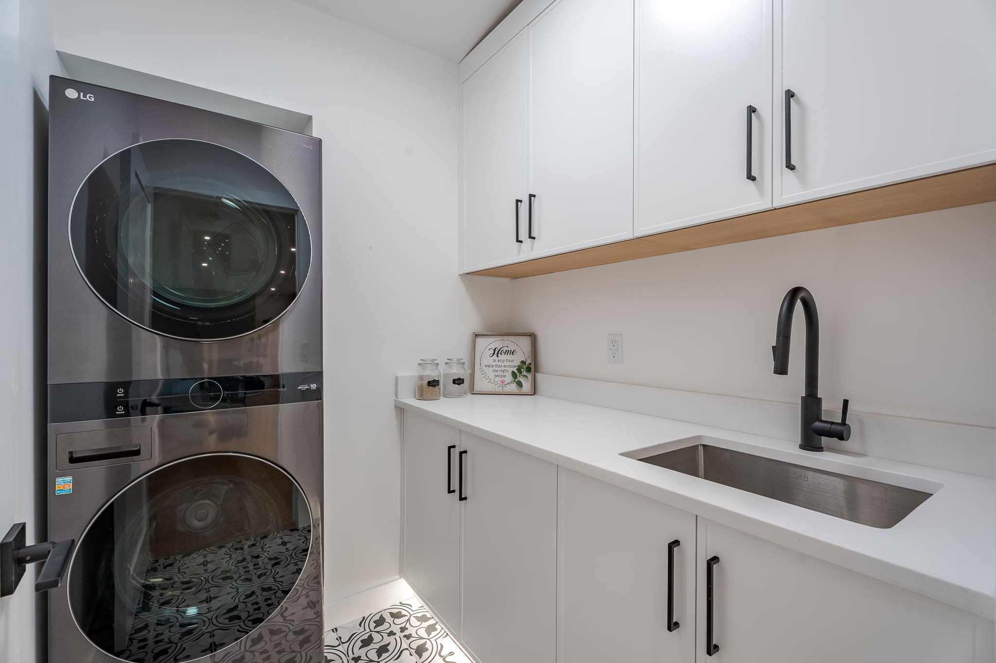 A kitchen with white cabinets and black appliances.