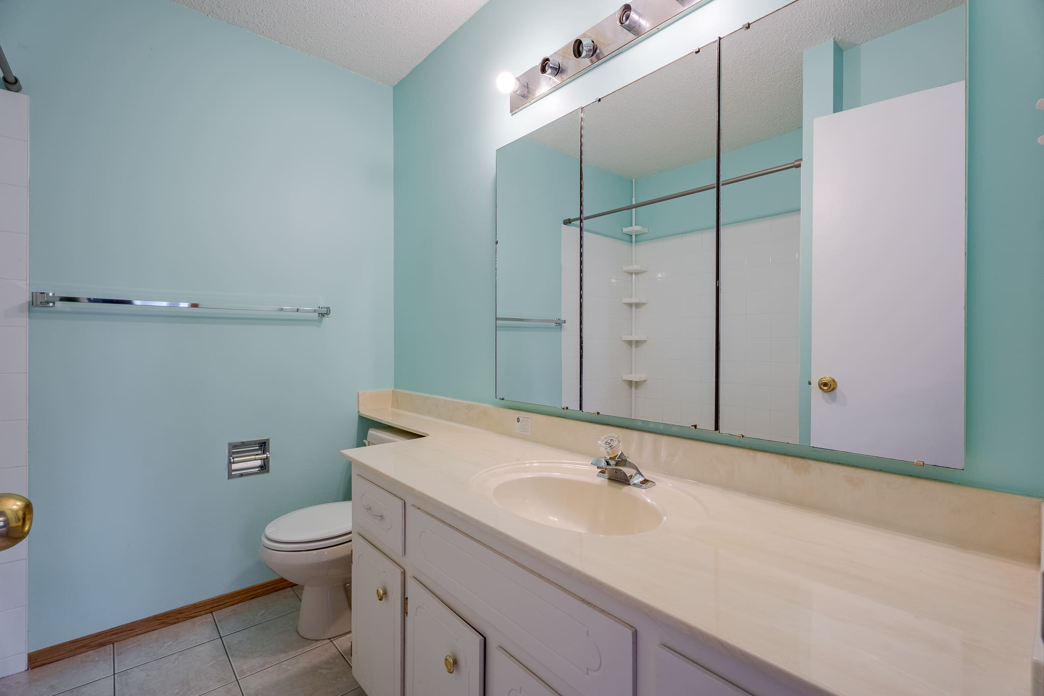 A bathroom with a large mirror and sink.