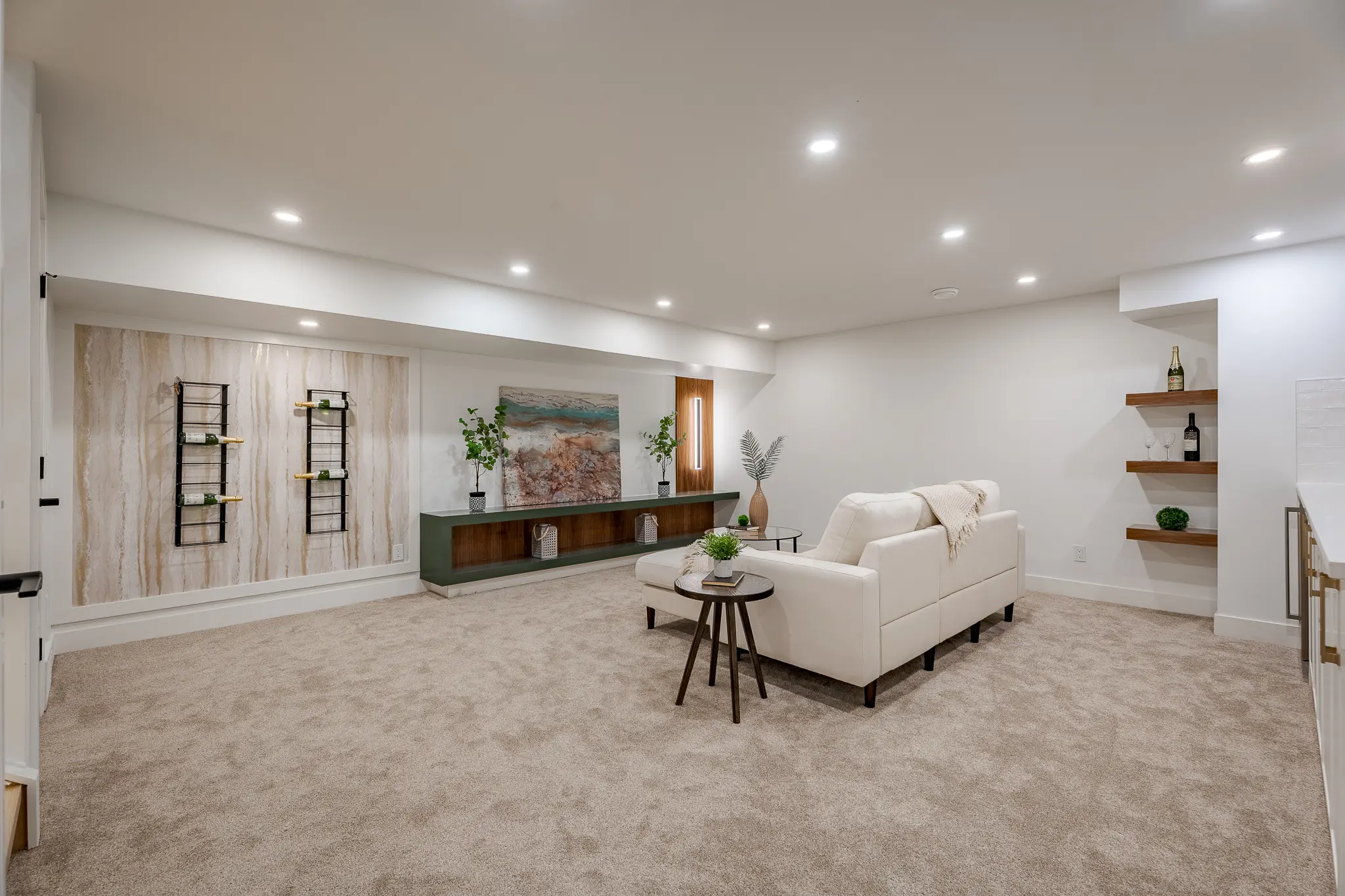 A living room with white walls and beige carpet.