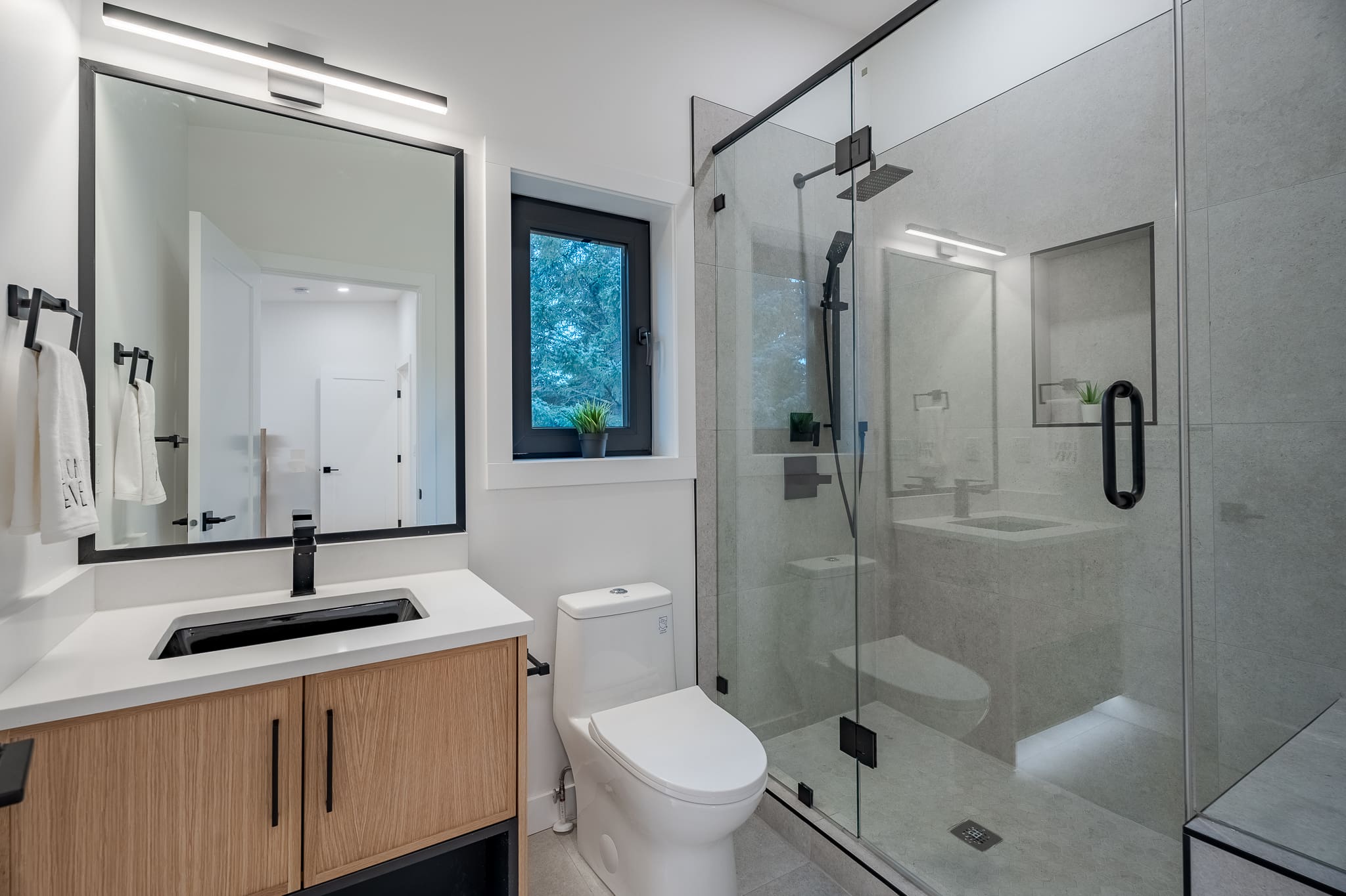 A bathroom with a toilet, sink and shower.