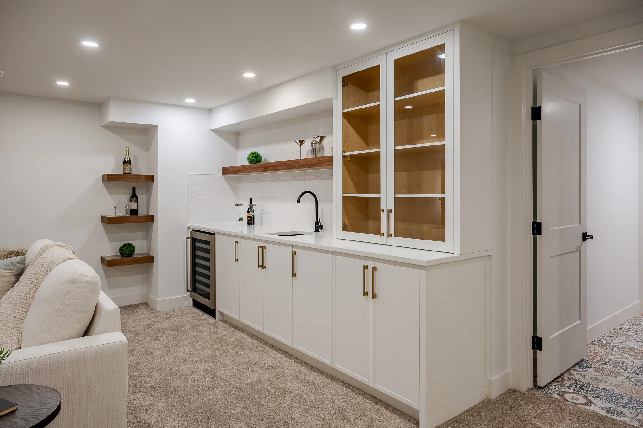 A kitchen with white cabinets and shelves in it