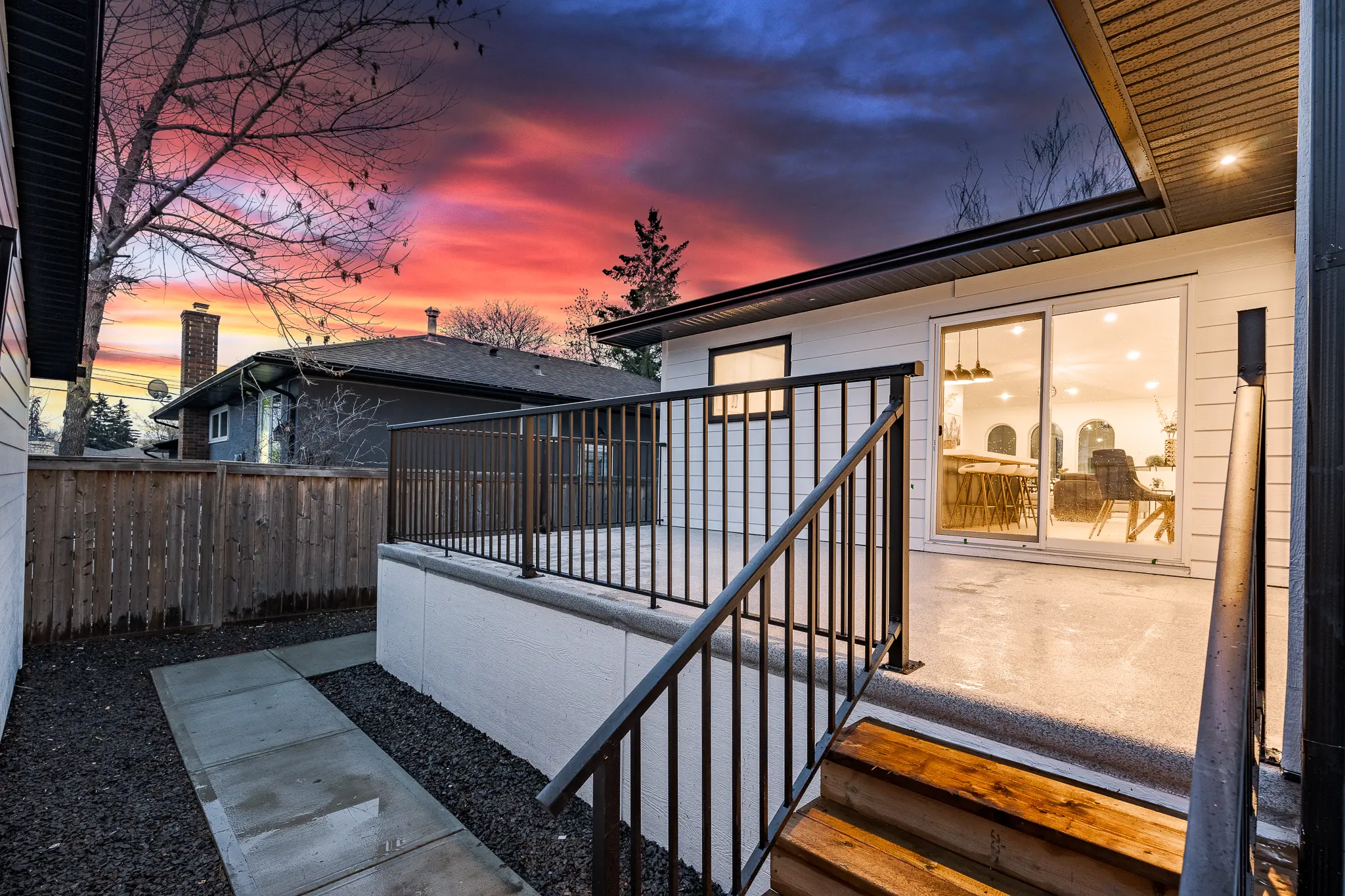 A house with a patio and stairs leading to the back deck.