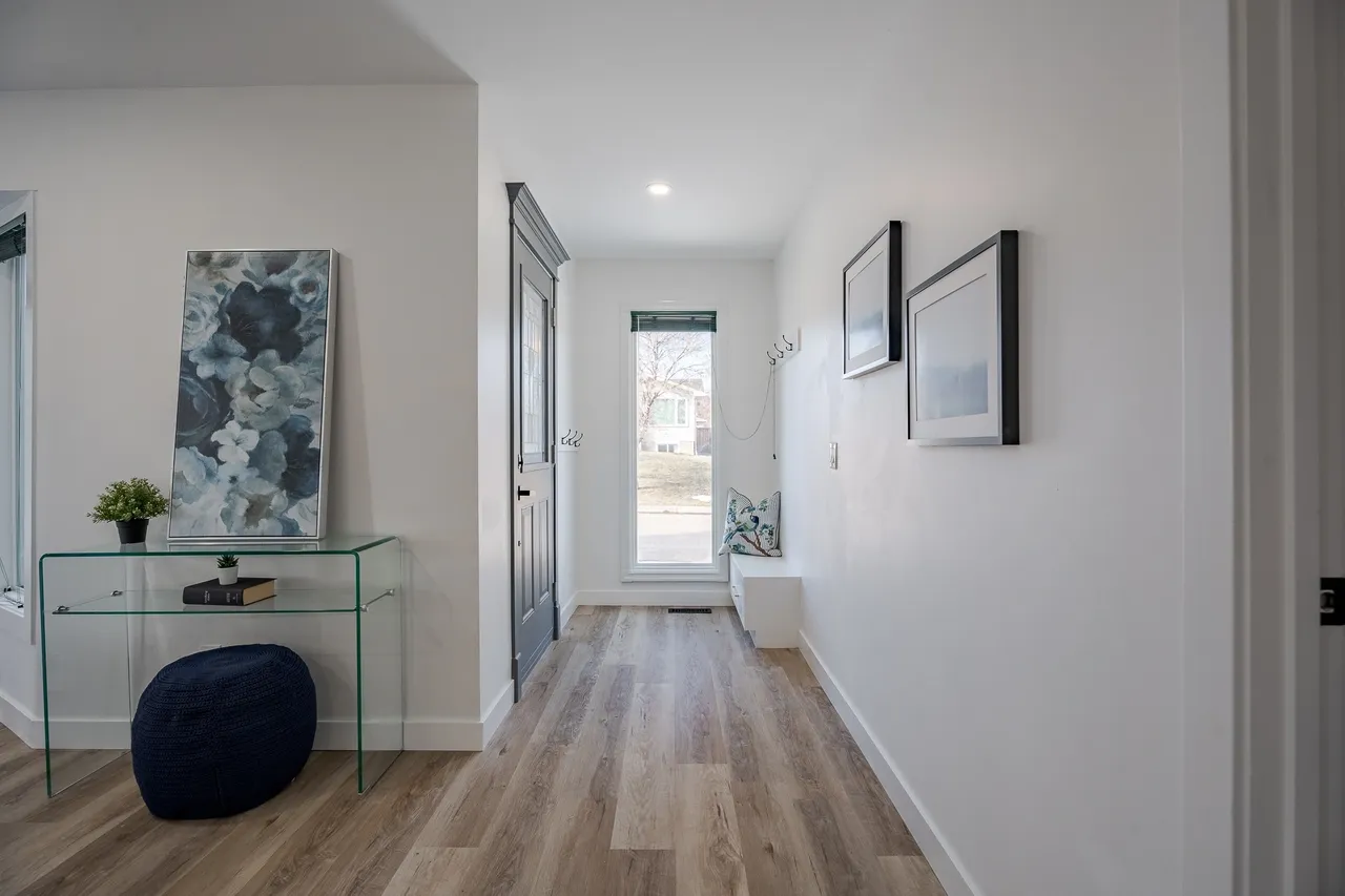 A hallway with a glass door and wooden floors