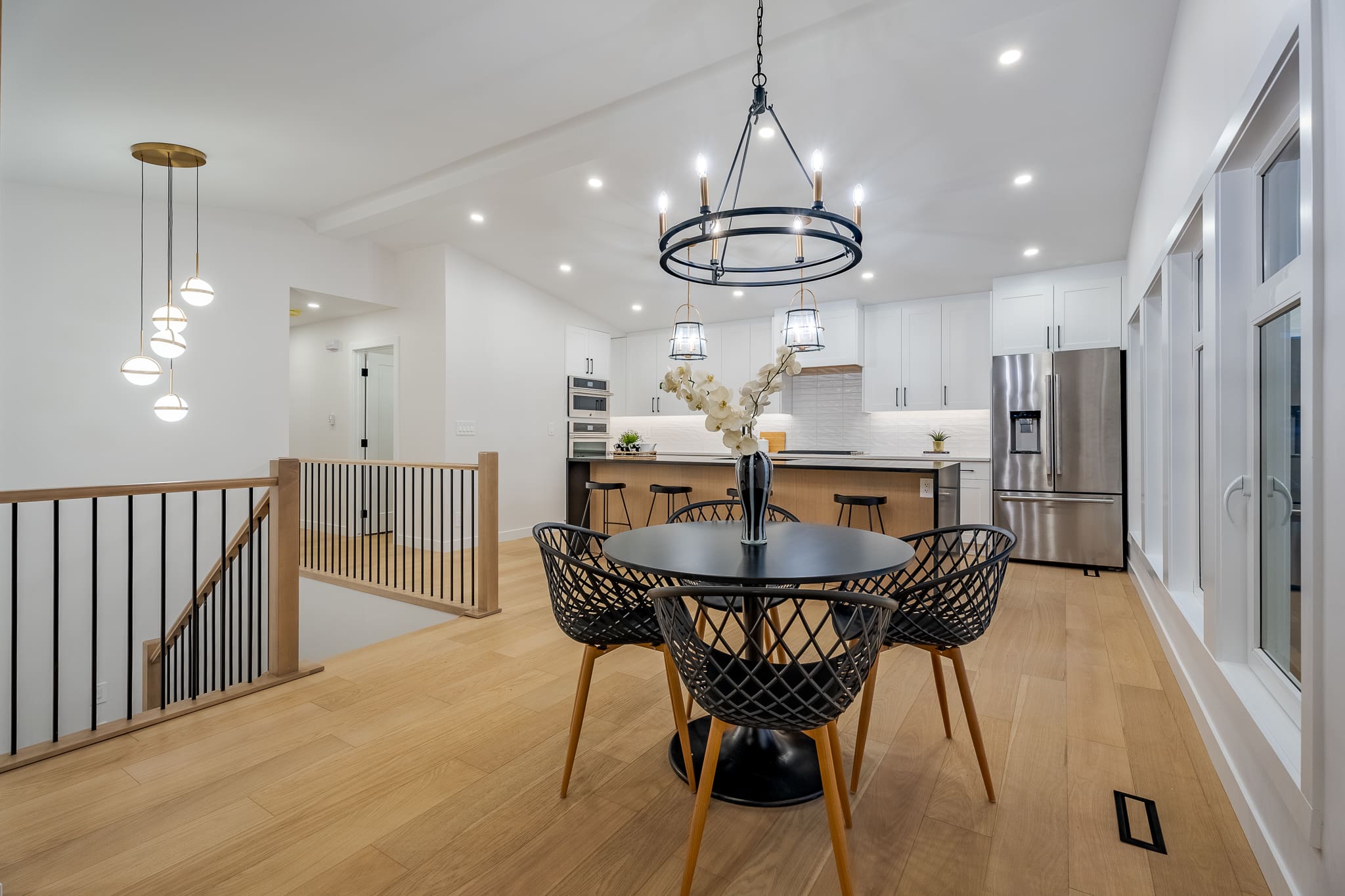 A dining room table and chairs in the middle of a kitchen.