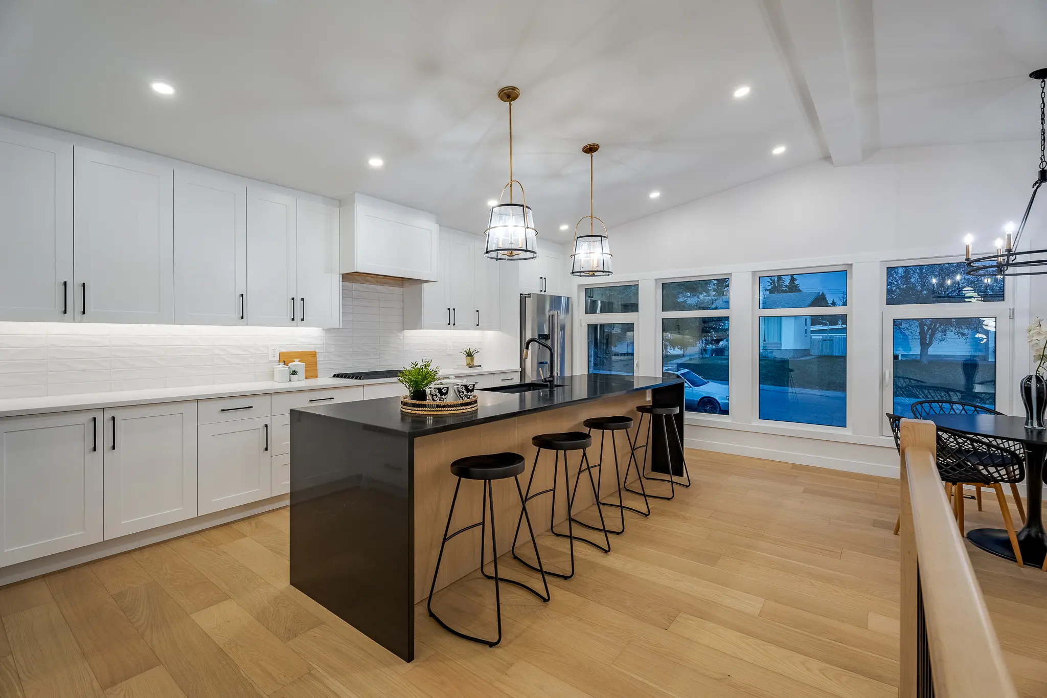 A kitchen with white walls and black island.