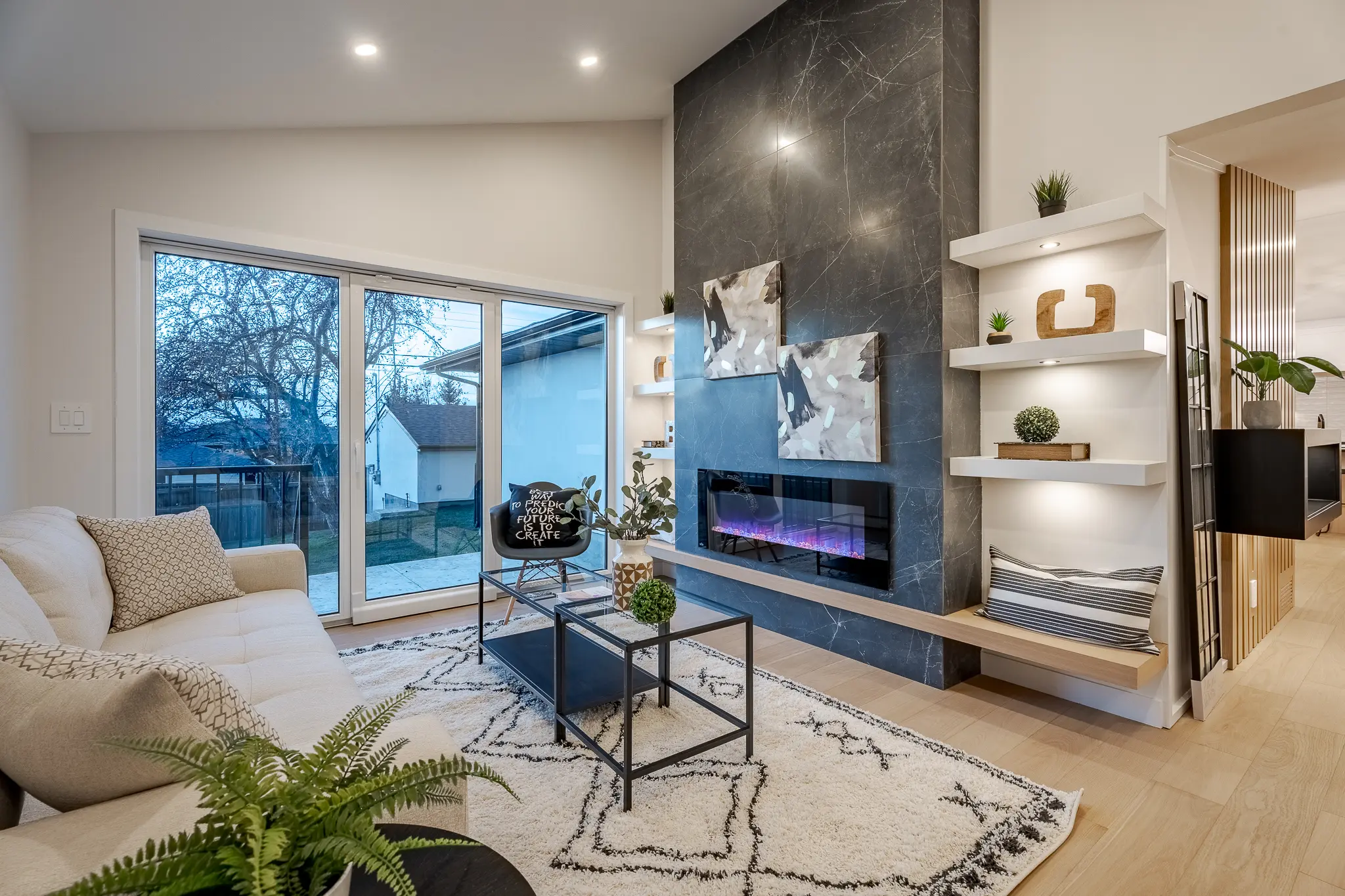 A living room with a fireplace and a large window.