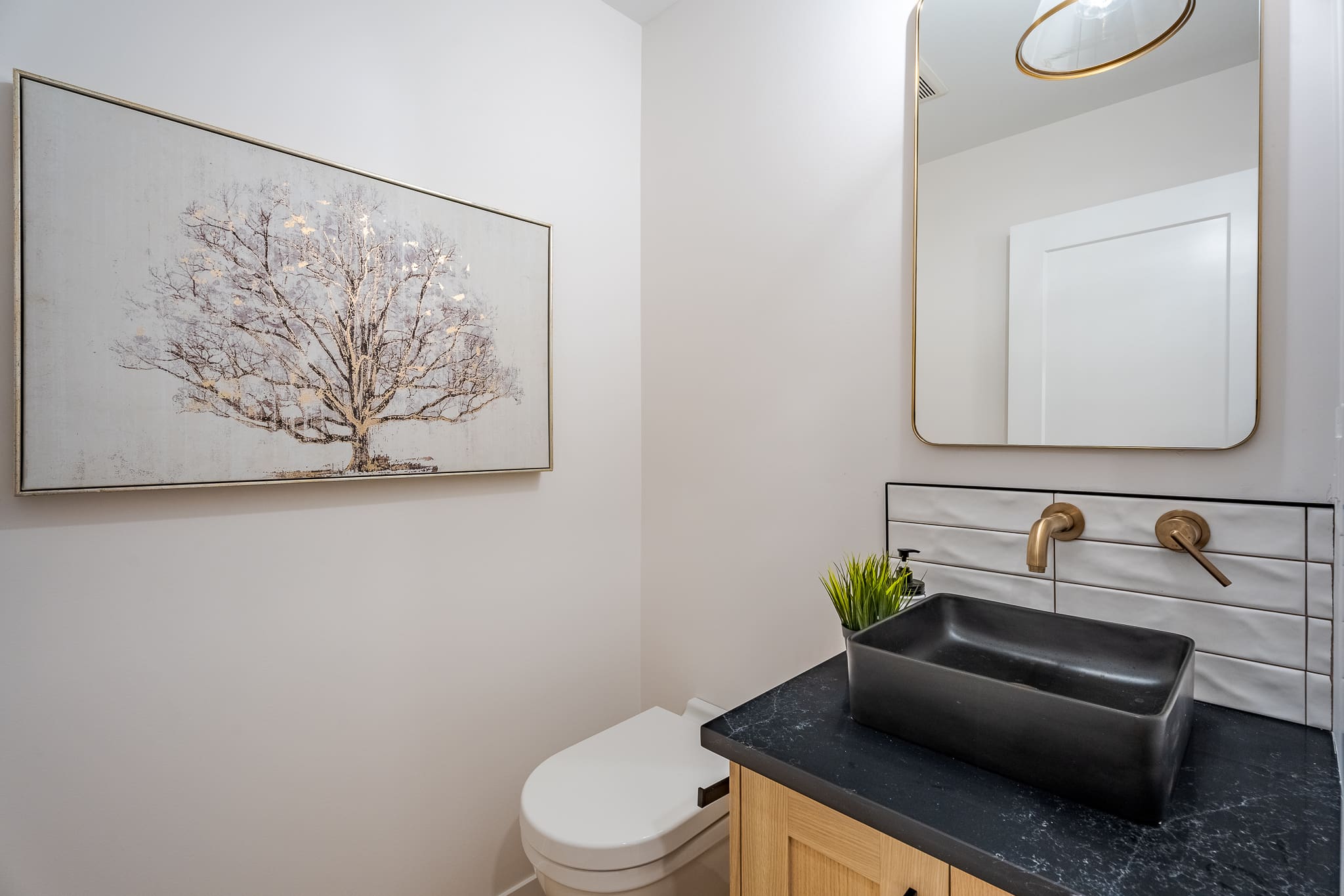 A bathroom with a sink, toilet and mirror.