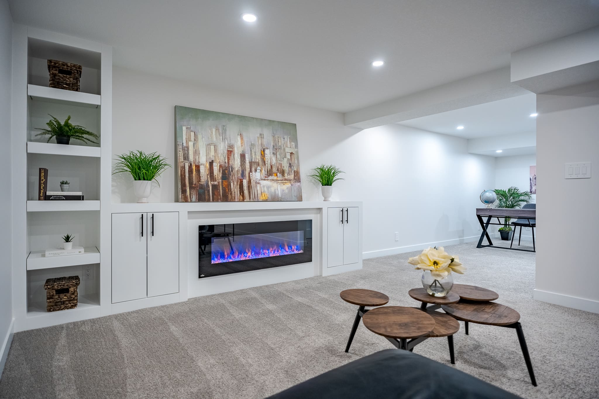 A living room with a fireplace and white cabinets